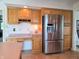 Modern kitchen with stainless steel refrigerator, wooden cabinetry, and built-in desk area at 515 E Hoover Dr, Nineveh, IN 46164