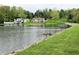 Picturesque view of waterfront homes on the lake, complemented by a meticulously maintained grassy bank at 515 E Hoover Dr, Nineveh, IN 46164
