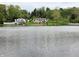 Expansive lake view reveals multiple waterfront properties with the calm water reflecting the sky, amidst lush greenery at 515 E Hoover Dr, Nineveh, IN 46164