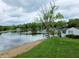Scenic waterfront view with a well-maintained lawn, leading to the calm lake waters surrounded by lush greenery at 515 E Hoover Dr, Nineveh, IN 46164