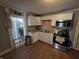 Bright and efficient kitchen with white cabinetry, stainless steel appliances, and laminate flooring at 533 W Pike St, Martinsville, IN 46151