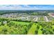 The aerial view showcases a community with manicured lawns and a community pond surrounded by trees at 5580 Pintail Ln, Greenwood, IN 46143