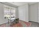 A bedroom with light grey walls, a storage closet, large window, colorful rug, and a art table at 5580 Pintail Ln, Greenwood, IN 46143