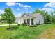 Beautifully landscaped front yard featuring a manicured lawn, decorative shrubs, and a covered porch at 5580 Pintail Ln, Greenwood, IN 46143