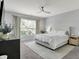 This spacious bedroom boasts a ceiling fan, a large window with natural light and modern furnishings at 5580 Pintail Ln, Greenwood, IN 46143