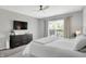 This main bedroom features a TV and a large window with curtains for a comfortable and modern feel at 5580 Pintail Ln, Greenwood, IN 46143