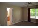 Bedroom with a window, carpet, ceiling fan, and an open door to the bathroom at 5708 Outer Bank Rd, Indianapolis, IN 46239