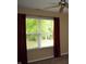 A view of the outside through a window with red curtains on either side at 5708 Outer Bank Rd, Indianapolis, IN 46239