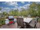 Back deck with grill, table and chairs, overhead lighting, and a backyard view at 6270 Lancaster Pl, Zionsville, IN 46077