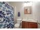 Bathroom with toilet, sink, wood vanity, a blue curtain with leaves and a towel at 6270 Lancaster Pl, Zionsville, IN 46077