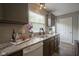 Bright kitchen features granite countertops, stainless sink, tile backsplash, and dark wood cabinets at 6270 Lancaster Pl, Zionsville, IN 46077