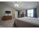 Comfortable main bedroom featuring a ceiling fan, a window with blue curtains, and carpet flooring at 6270 Lancaster Pl, Zionsville, IN 46077