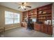 Home office has built-in wood cabinets, drawers, shelves, and carpeted floor at 6270 Lancaster Pl, Zionsville, IN 46077