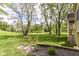 Landscaped backyard with mature trees and a retaining wall flower garden at 6340 W 800 S, Pendleton, IN 46064