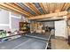 Unfinished basement with ping pong table, boxes, and door leading outside at 6340 W 800 S, Pendleton, IN 46064
