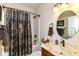 Well-lit bathroom featuring vanity with a marble countertop, dark fixtures, and a shower with patterned curtain at 6340 W 800 S, Pendleton, IN 46064