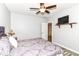 Cozy bedroom with ceiling fan, TV on shelf, and purple patterned bedspread at 6340 W 800 S, Pendleton, IN 46064