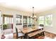 Bright dining room featuring a wooden table with bench seating and views into a sunroom at 6340 W 800 S, Pendleton, IN 46064
