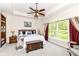 Bright main bedroom featuring a tray ceiling, large window, ceiling fan, and a built-in bookcase at 6340 W 800 S, Pendleton, IN 46064