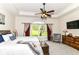A main bedroom with a tray ceiling, large window, a ceiling fan, and stylish furnishings at 6340 W 800 S, Pendleton, IN 46064
