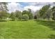 Vast green lawn with mature trees and landscaping creates a park-like setting, perfect for outdoor activities at 6340 W 800 S, Pendleton, IN 46064