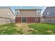 View of the backyard and back of the home featuring a brick wall, lawn, and fence at 6540 Mccreery Ct, Indianapolis, IN 46221