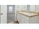 Bathroom featuring double sinks, white cabinets, and a view into the bedroom at 6540 Mccreery Ct, Indianapolis, IN 46221