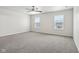 Spacious bedroom featuring plush gray carpeting and ample natural light from two windows at 6540 Mccreery Ct, Indianapolis, IN 46221
