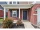 Close-up of home's front entry featuring a brick facade, covered porch, and a dark front door at 6540 Mccreery Ct, Indianapolis, IN 46221