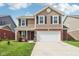 Inviting two-story home featuring brick and vinyl siding, a two-car garage, and a well-manicured lawn at 6540 Mccreery Ct, Indianapolis, IN 46221