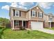 Traditional two-story home featuring a two-car garage, brick accents, and a manicured lawn at 6540 Mccreery Ct, Indianapolis, IN 46221