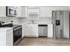 Modern kitchen showcasing stainless steel appliances, white cabinets, and wood-look flooring at 6540 Mccreery Ct, Indianapolis, IN 46221