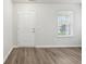 Bright living room with new vinyl floors, a large window, and a white front door at 6540 Mccreery Ct, Indianapolis, IN 46221