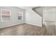 Spacious living area featuring new vinyl flooring, natural light, and a staircase in the background at 6540 Mccreery Ct, Indianapolis, IN 46221