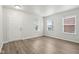 Neutral living area with vinyl plank flooring, ample natural light from three windows, and white trim at 6540 Mccreery Ct, Indianapolis, IN 46221