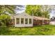 Home's backyard showcasing the sunroom, brick exterior, and green lawn at 728 E Main St, Carmel, IN 46032