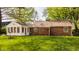 Backyard featuring a brick house with a sunroom addition and a grassy lawn at 728 E Main St, Carmel, IN 46032