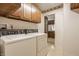 Laundry room with appliances and wooden cabinets, adjoining another room at 728 E Main St, Carmel, IN 46032