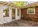 Brick patio with a glass door leading to the house, surrounded by greenery at 728 E Main St, Carmel, IN 46032