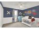 Sweet Bedroom with dinosaur theme, blue accent wall, white crib, and cheerful decor at 769 Canberra Blvd, Westfield, IN 46074