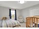 Comfortable carpeted bedroom featuring a cot, crib, armchair and window at 769 Canberra Blvd, Westfield, IN 46074