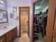 Bathroom leading to the toilet/shower and walk-in closet, with a sink, mirror, and storage, all beautifully lit at 7814 Crooked Meadows Dr, Indianapolis, IN 46268