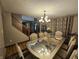 Elegant dining room featuring wood floors, a large table with seating for six, decorative lighting, and a view of the staircase at 7814 Crooked Meadows Dr, Indianapolis, IN 46268