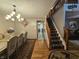 Elegant dining room with wood floors, a large table with seating for six, decorative lighting and a view of the staircase at 7814 Crooked Meadows Dr, Indianapolis, IN 46268