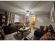 Inviting living room featuring plush seating, decorative curtains, a ceiling fan, wood-look floors and ample natural light at 7814 Crooked Meadows Dr, Indianapolis, IN 46268