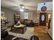Inviting living room featuring plush seating, decorative curtains, a ceiling fan, wood-look floors, and a front door view at 7814 Crooked Meadows Dr, Indianapolis, IN 46268