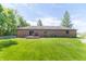 Expansive backyard view showing a brick home with a small deck and plenty of green space at 8292 E 100 S, Greenfield, IN 46140