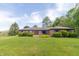 Charming single-story brick home featuring well-maintained landscaping and a lush green lawn at 8292 E 100 S, Greenfield, IN 46140