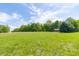 Picturesque view of the property featuring lush greenery, mature trees, and a small red barn structure at 8292 E 100 S, Greenfield, IN 46140