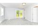 Carpeted bedroom with backyard deck access, neutral paint, and multiple closets at 8308 W Main St, Coatesville, IN 46121